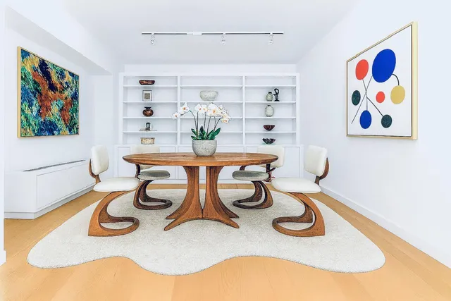 a table with chairs and painting on a wall