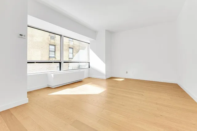 a view of empty room with wooden floor and windows
