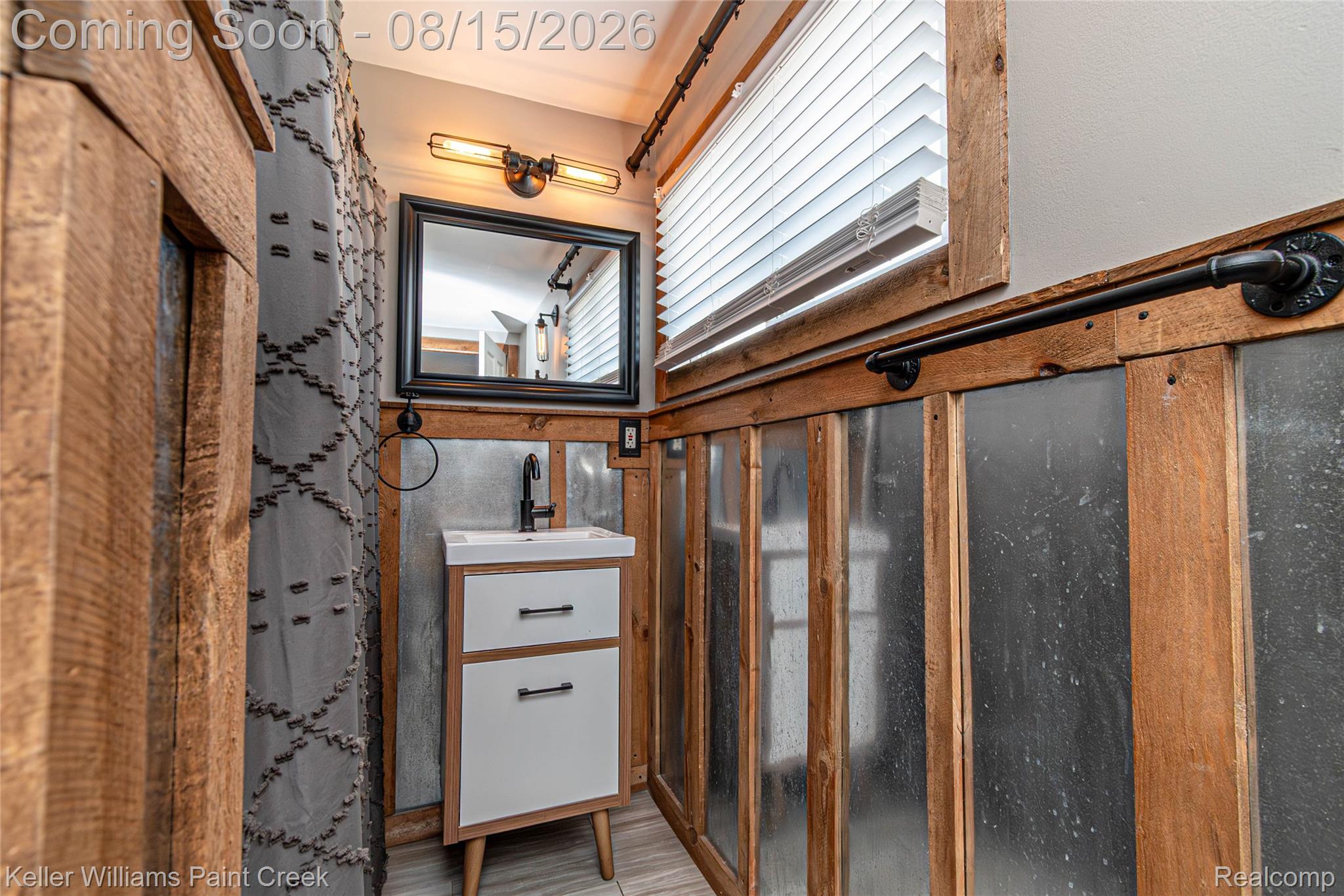 330 East Washington Street Romeo, MI 48065 - Photo 47 of 68 Vanity with integrated sink, wood-finish and metal paneling, industrial-style lighting, and a framed mirror