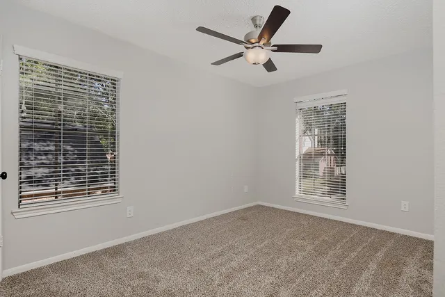 a view of a livingroom with a ceiling fan and window