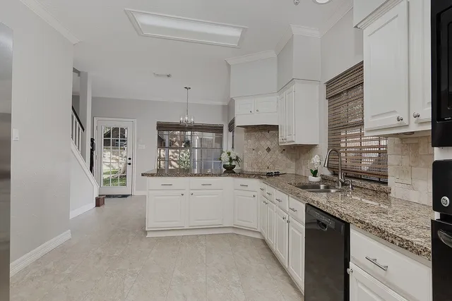 a kitchen with granite countertop a sink stove top oven and cabinets