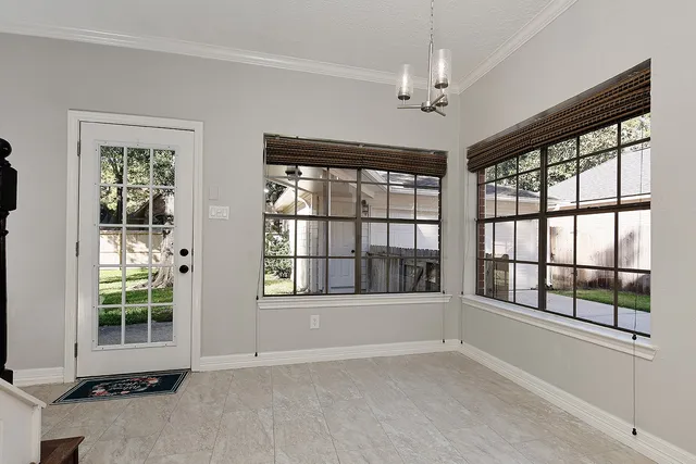 an empty room with windows and chandelier