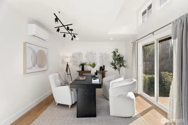 a living room with couches a coffee table and potted plant with wooden floor