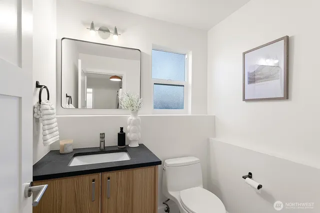 a bathroom with a toilet a sink and mirror