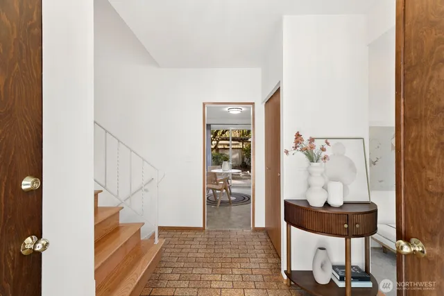 a view of a hallway to a livingroom with furniture