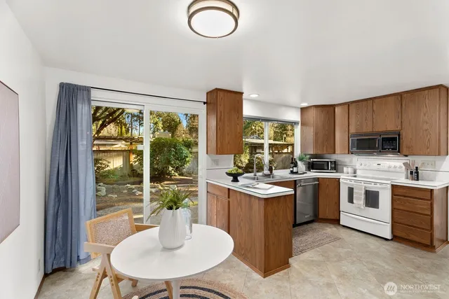 a kitchen with sink refrigerator dining table and chairs
