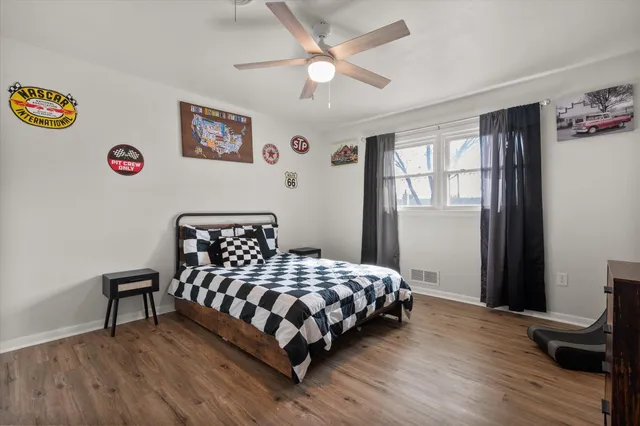 a bedroom with a bed and a table in it with wooden floor