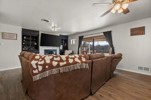 a living room with furniture a chandelier and a wooden floor