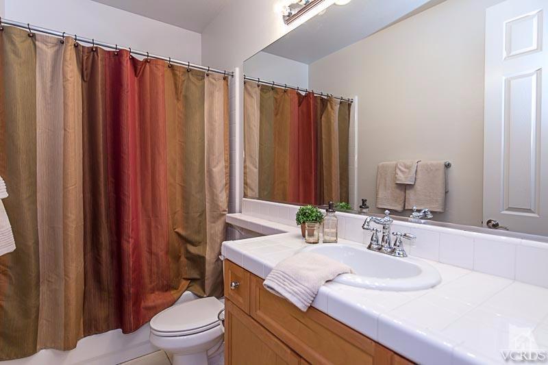 12366 Nelson Road Moorpark, CA 93021 - Photo 44 of 67 a bathroom with a granite countertop sink toilet and shower