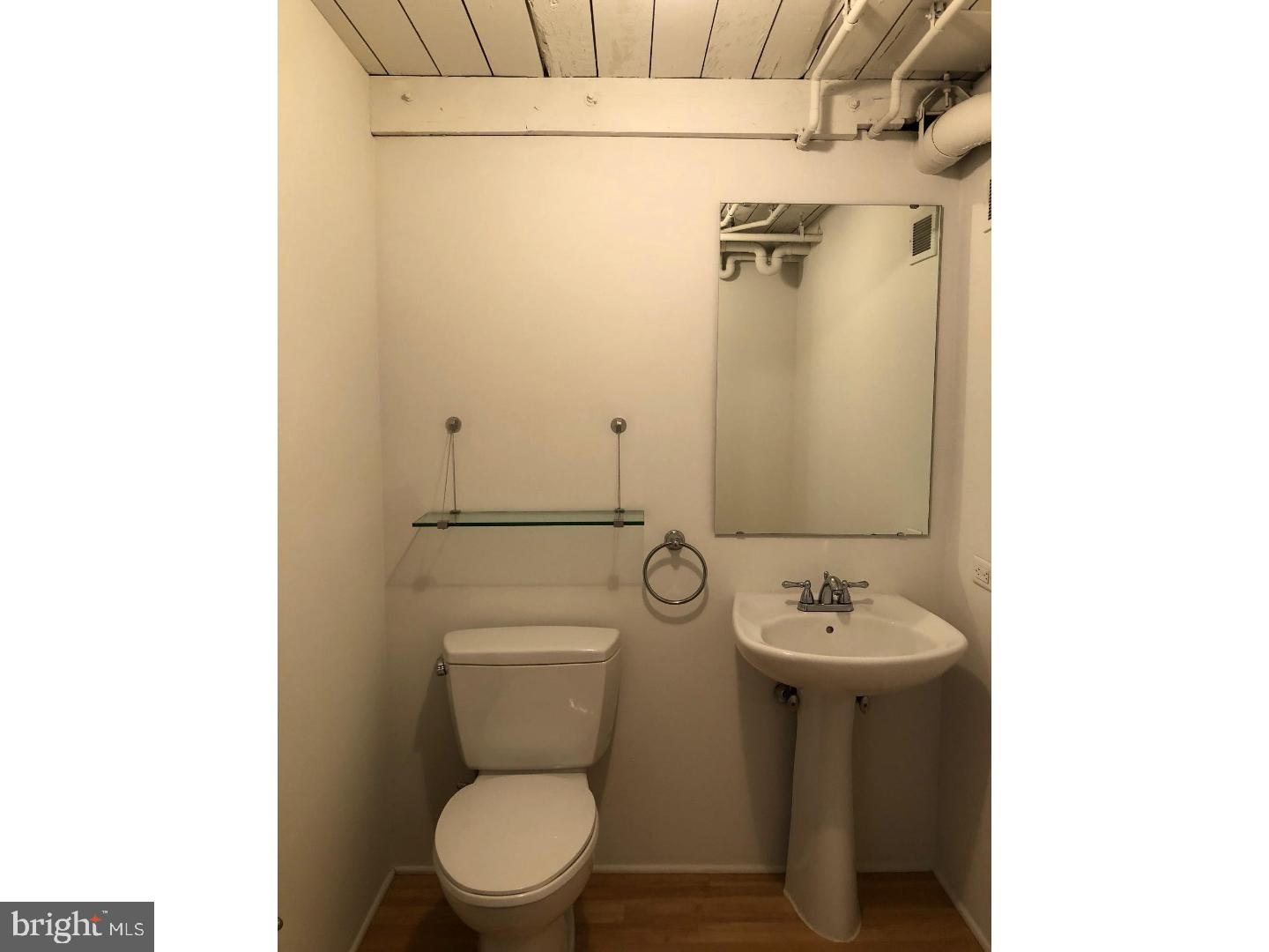 2300 Walnut Street, Unit 3B430 Philadelphia, PA 19103 - Photo 9 of 11 a bathroom with a toilet a sink and mirror