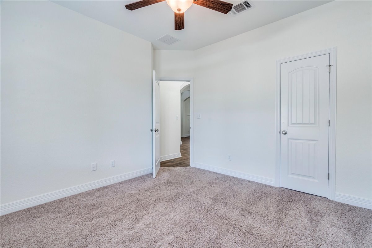 5009 Inks Clearing Lane Austin, TX 78738 - Photo 29 of 34 Neutral walls and plush carpeting create a versatile, comfortable bedroom space.