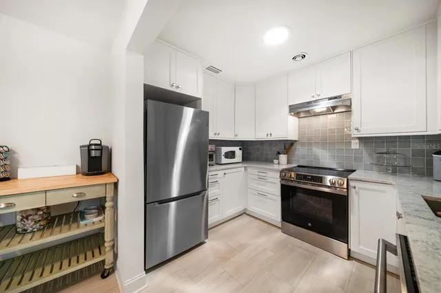 a kitchen with stainless steel appliances granite countertop a refrigerator stove and sink