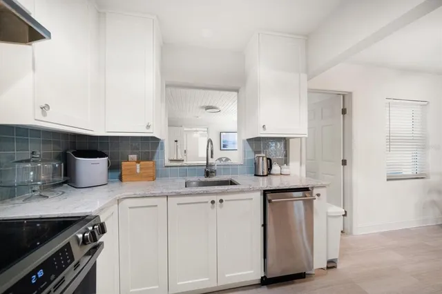 a kitchen with granite countertop white cabinets and white appliances