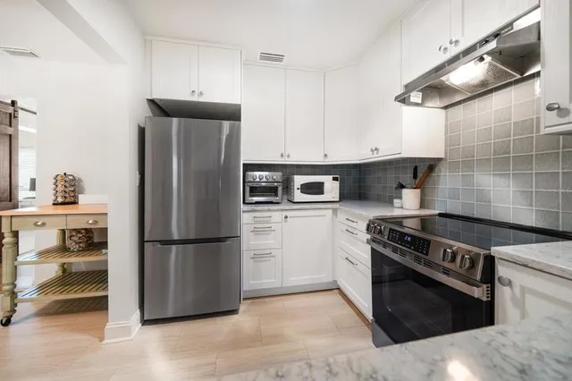 a kitchen with a stove refrigerator and cabinets