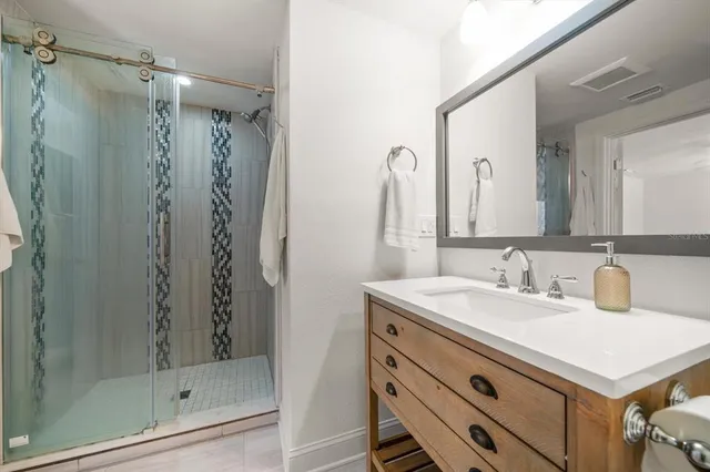 a bathroom with a sink a mirror a vanity and shower