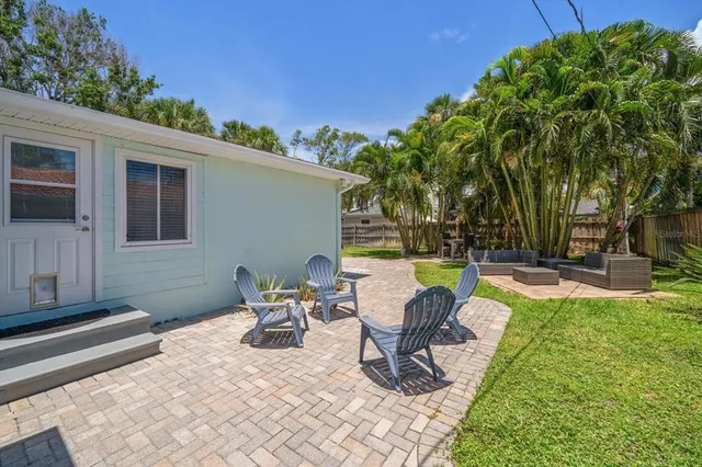 a view of a house with backyard and sitting area