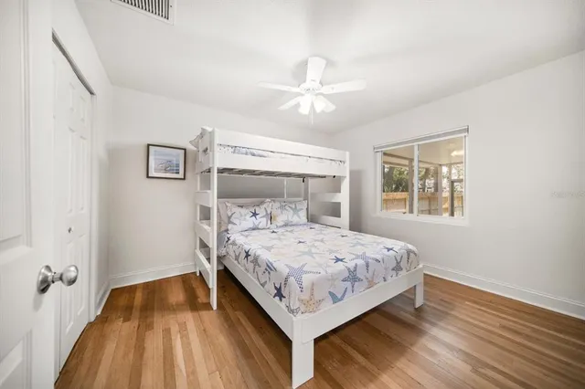 a bedroom with a bed and wooden floor
