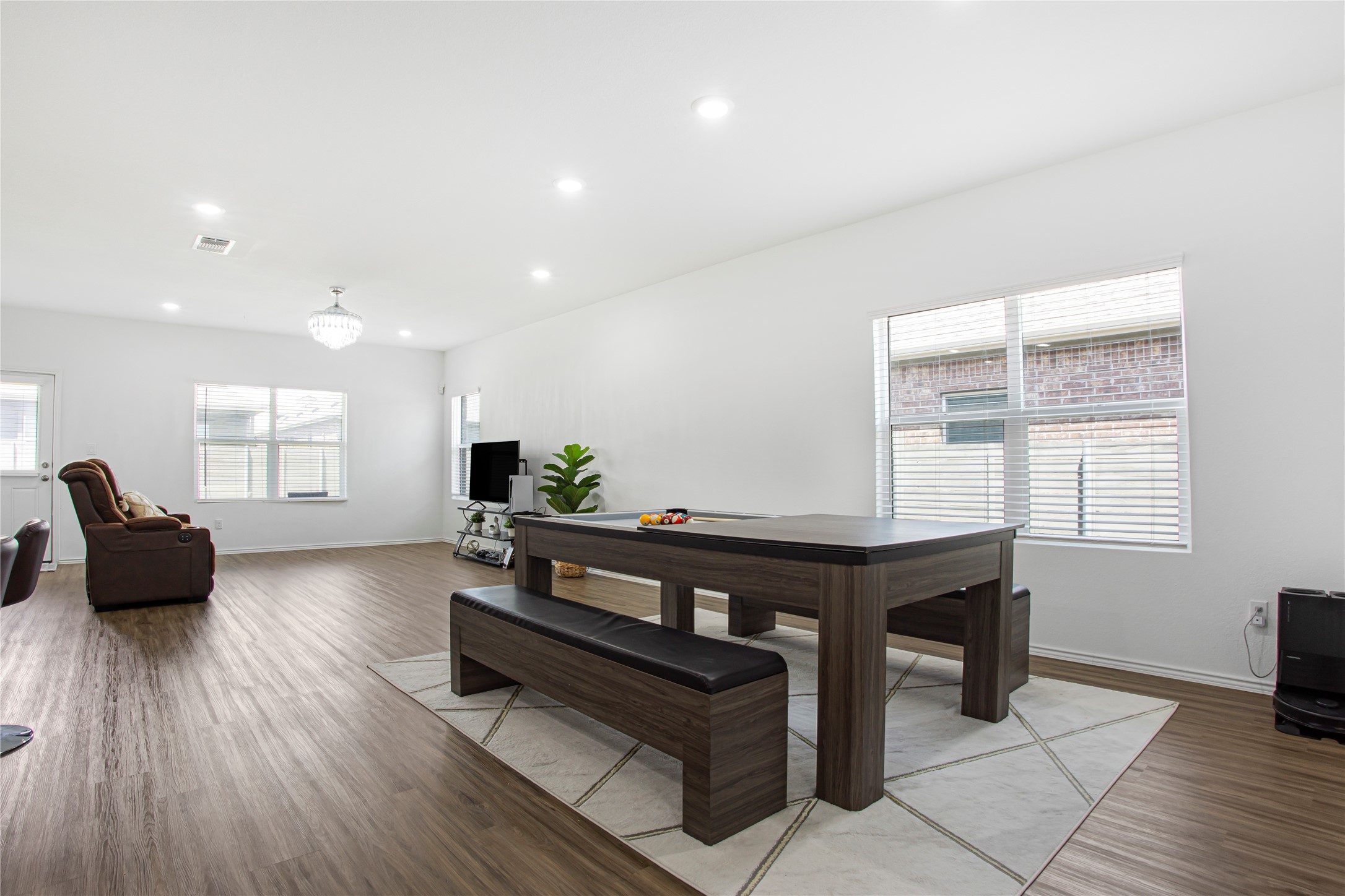 124 Cherry Ridge Road Georgetown, TX 78628 - Photo 8 of 23 Open-concept living area featuring wood-finish flooring, recessed lighting, white walls, and multiple windows with horizontal blinds