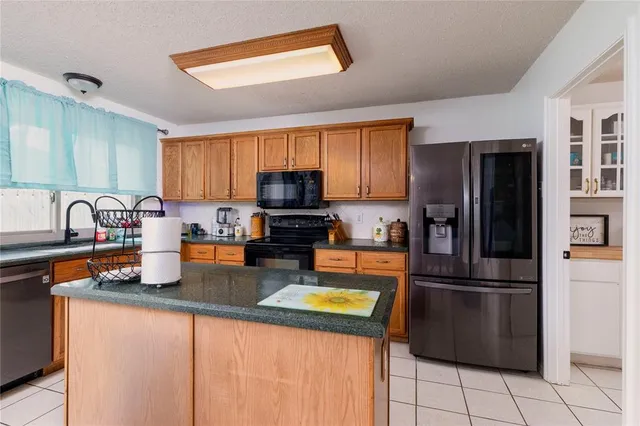 a kitchen with stainless steel appliances granite countertop a refrigerator stove microwave and sink