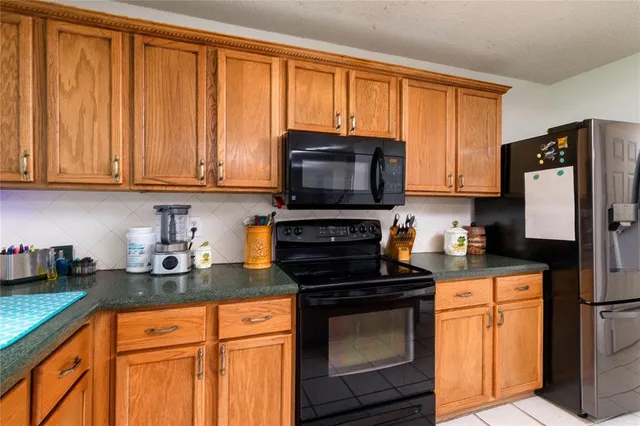 a kitchen with granite countertop a refrigerator stove and microwave