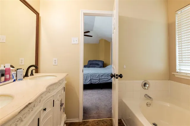 a en suite bathroom with a tub sink and mirror