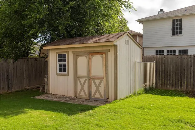 a view of backyard of house with wooden fence