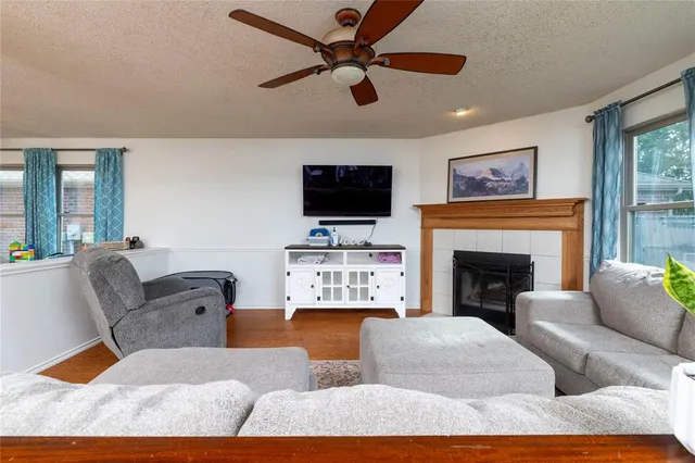 a living room with furniture a flat screen tv and a fireplace