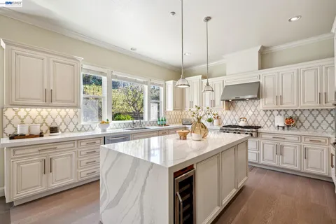 a kitchen with stainless steel appliances granite countertop a sink a stove and cabinets
