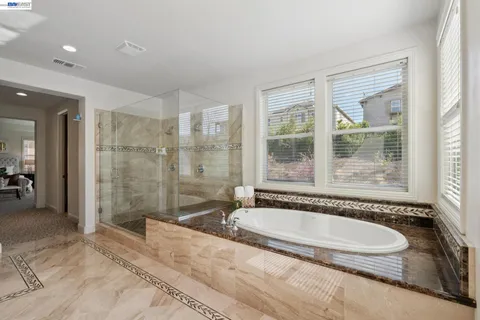 a bathroom with a granite countertop sink a mirror and a shower