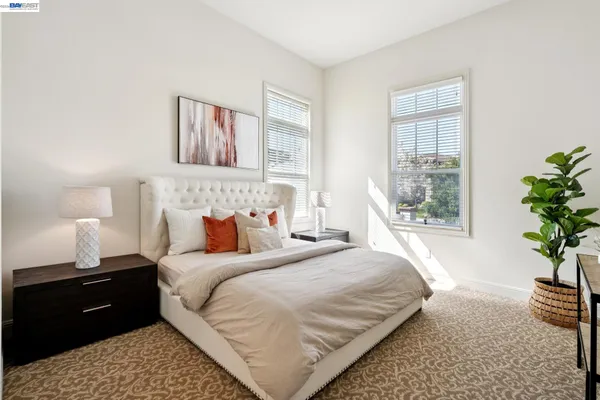 a bedroom with a bed and a painting on the wall
