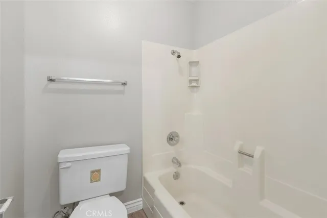 a white toilet sitting next to a bath tub