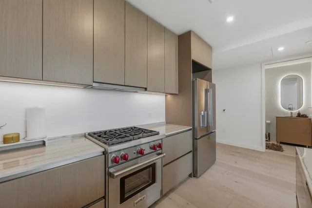 a kitchen with stainless steel appliances a stove a refrigerator and cabinets