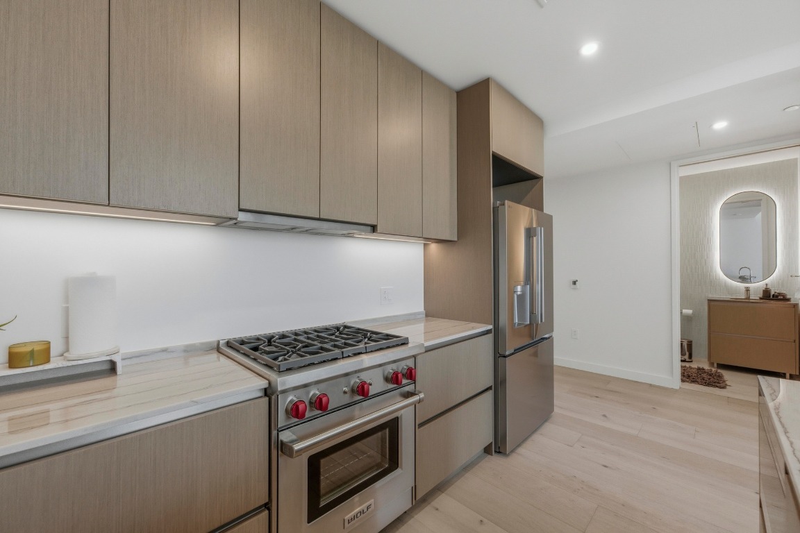 610 Davis Street, Unit 2710 Austin, TX 78701 - Photo 11 of 23 a kitchen with stainless steel appliances a stove a refrigerator and cabinets