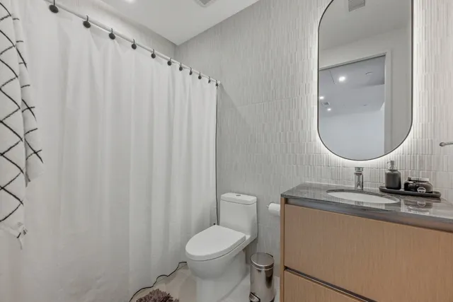 a bathroom with a sink toilet and a mirror