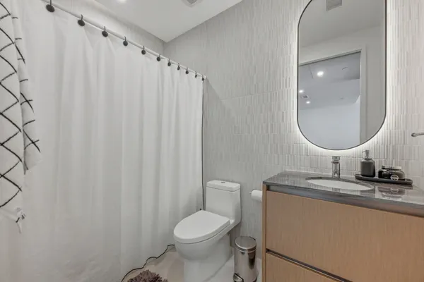 a bathroom with a sink toilet and a mirror