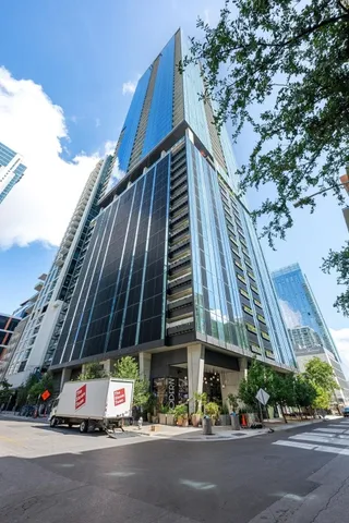 a city street with tall buildings and cars parked in front of it