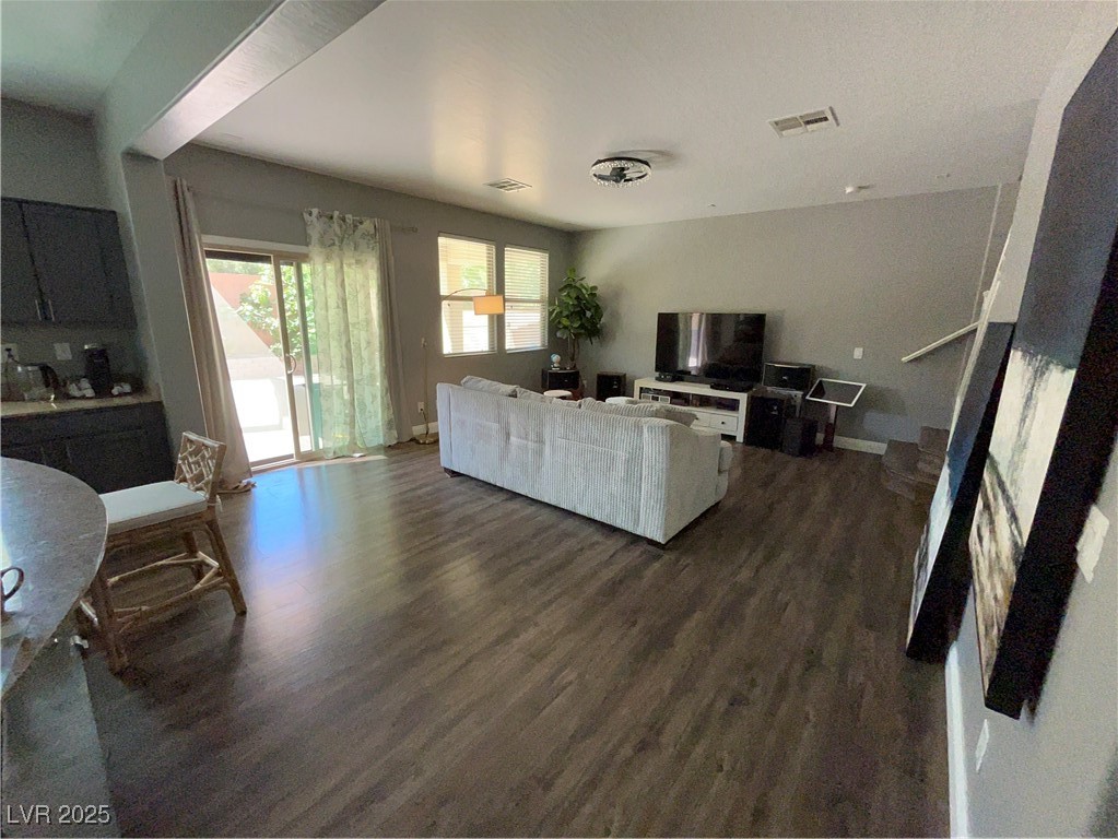 8977 Melridge Road Las Vegas, NV 89148 - Photo 18 of 35 Living room featuring baseboards, dark wood-style floors, and visible vents