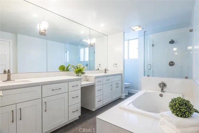 a spacious bathroom with a tub sink and mirror