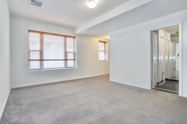 an empty room with closet and windows
