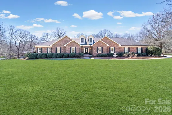 a front view of a house with a yard and trees