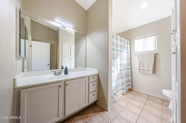 a spacious bathroom with a double vanity sink a mirror and a