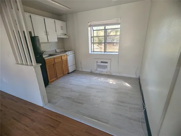 a view of a kitchen with wooden floor and electronic appliances