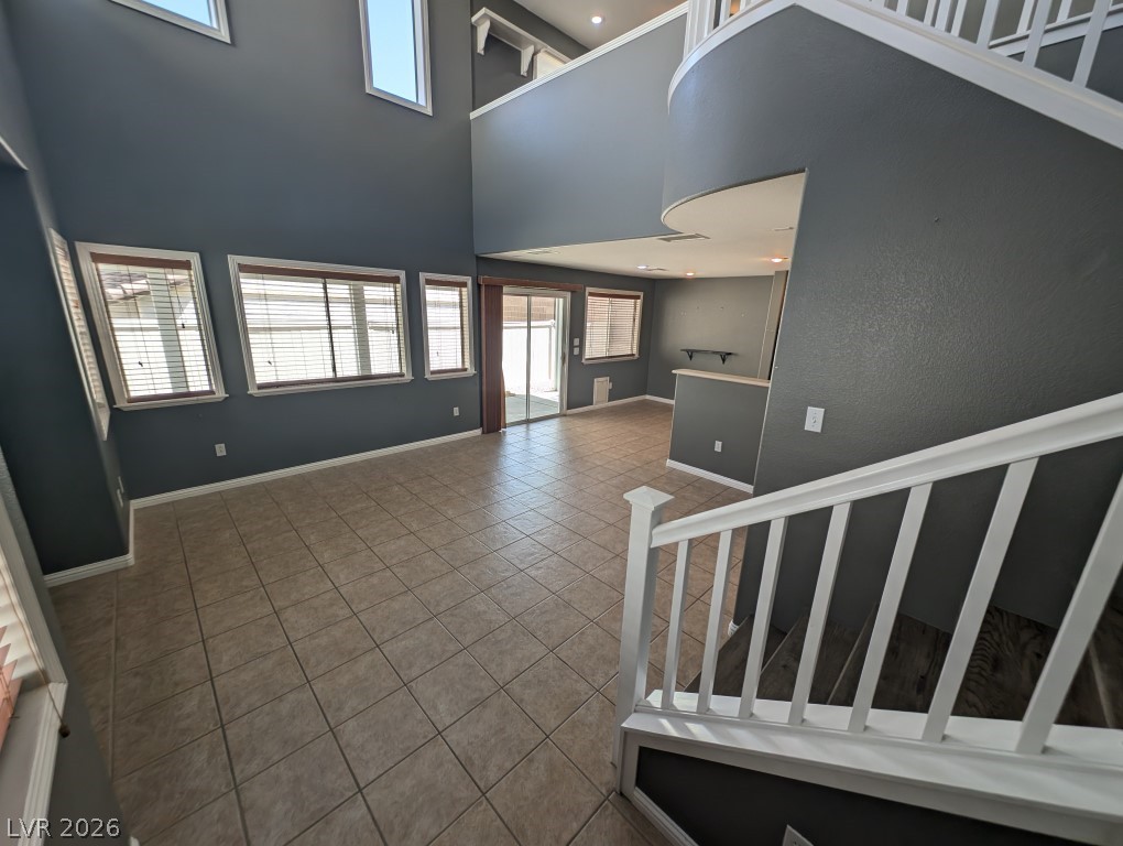 9121 Spoonbill Ridge Place Las Vegas, NV 89143 - Photo 2 of 26 A spacious entry with high ceilings welcomes you, featuring abundant natural light and tile flooring throughout.