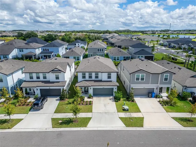 an aerial view of a house a swimming pool a patio and ocean view