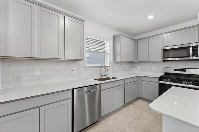 a kitchen with cabinets appliances a sink and a window