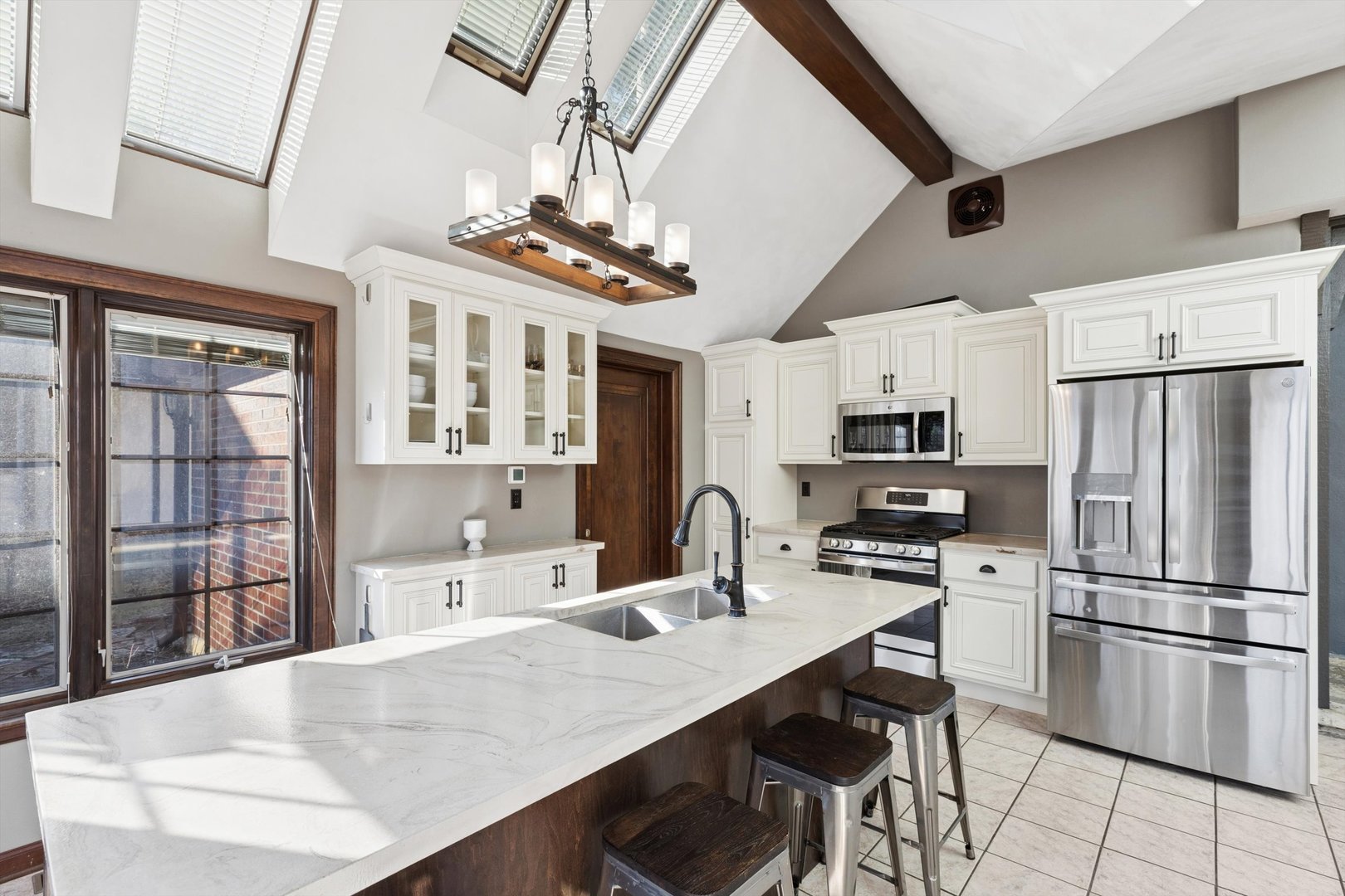 716 Terrace Drive Clinton, IA 52732 - Photo 35 of 78 a kitchen with stainless steel appliances a refrigerator a stove a sink dishwasher a dining table and chairs with wooden floor
