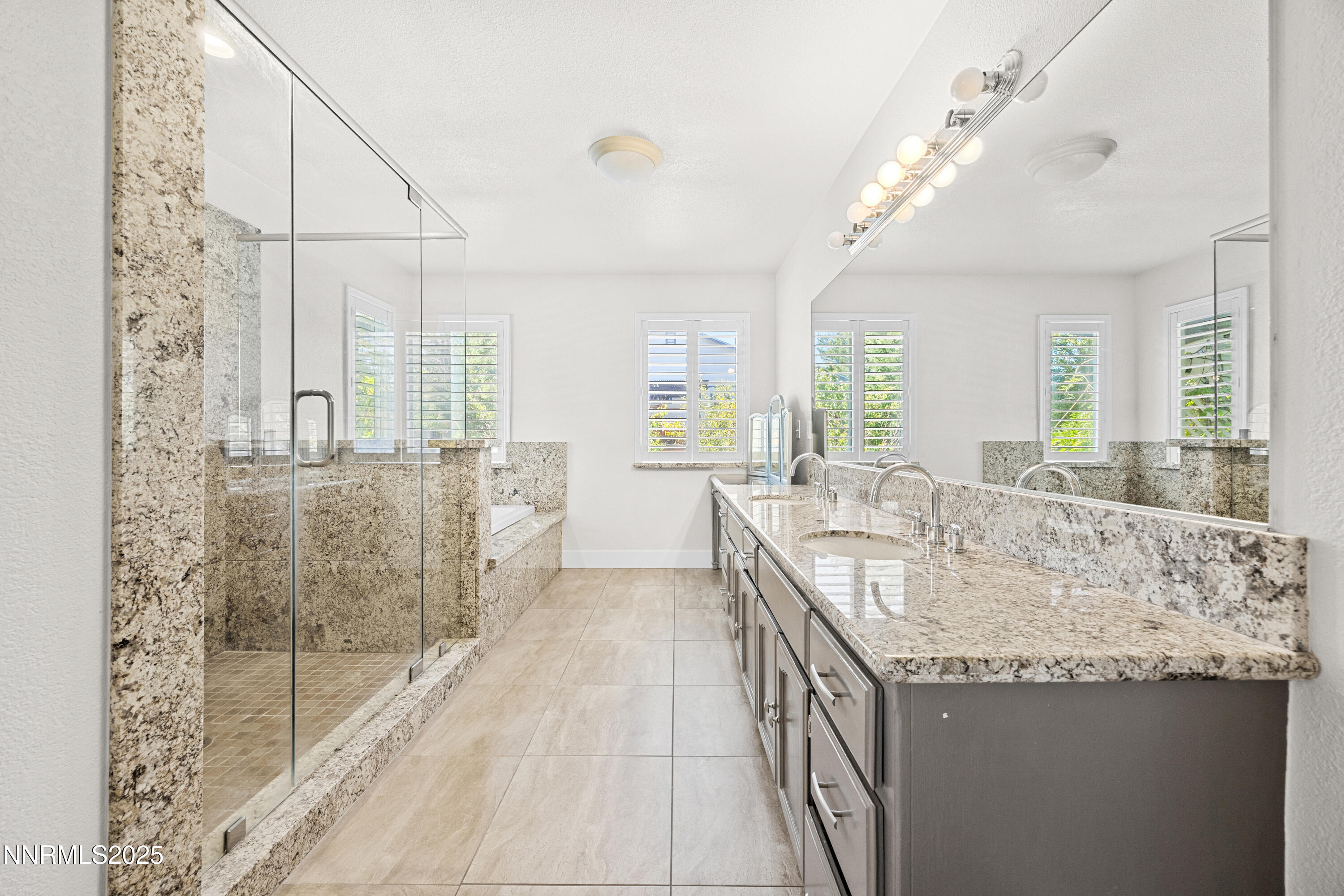 3510 Comstock Drive Reno, NV 89512 - Photo 17 of 37 a bathroom with a granite countertop sink a large mirror and shower