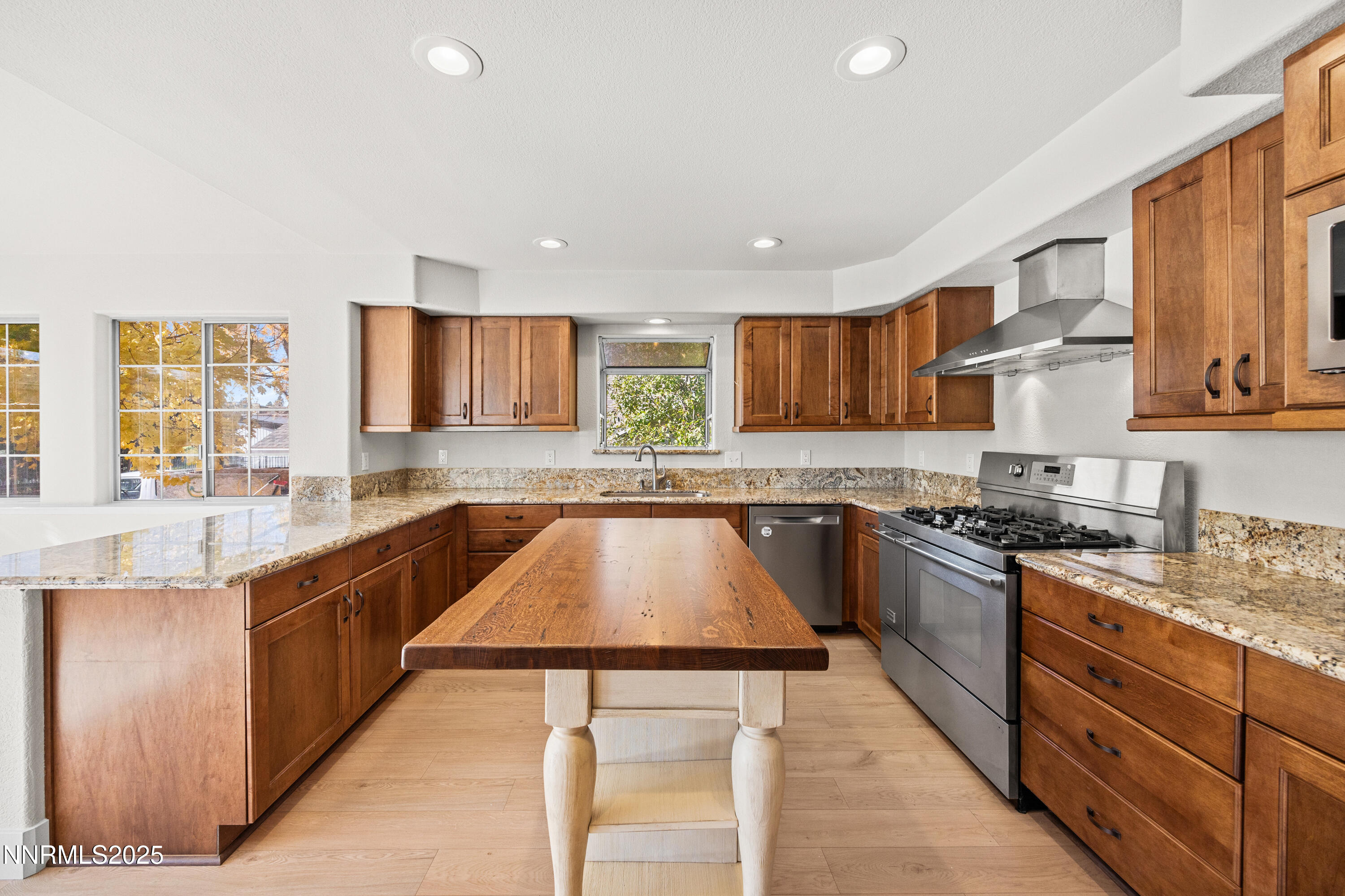 3510 Comstock Drive Reno, NV 89512 - Photo 7 of 37 a kitchen with stainless steel appliances granite countertop wooden cabinets a stove top oven a sink and dishwasher with wooden floor