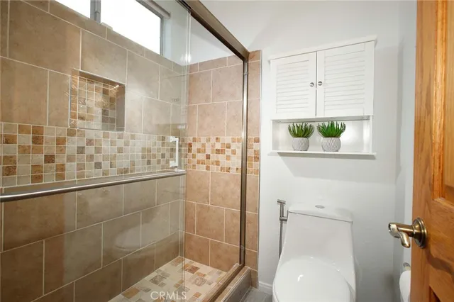 a bathroom with a granite countertop window a toilet and a shower