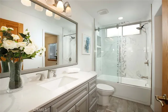 a bathroom with a granite countertop sink toilet and shower
